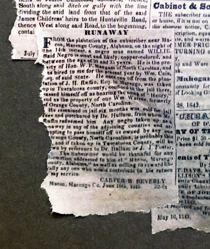 A slave runaway  newspaper ad is torn on the left side with the black board shown in this close up view. 